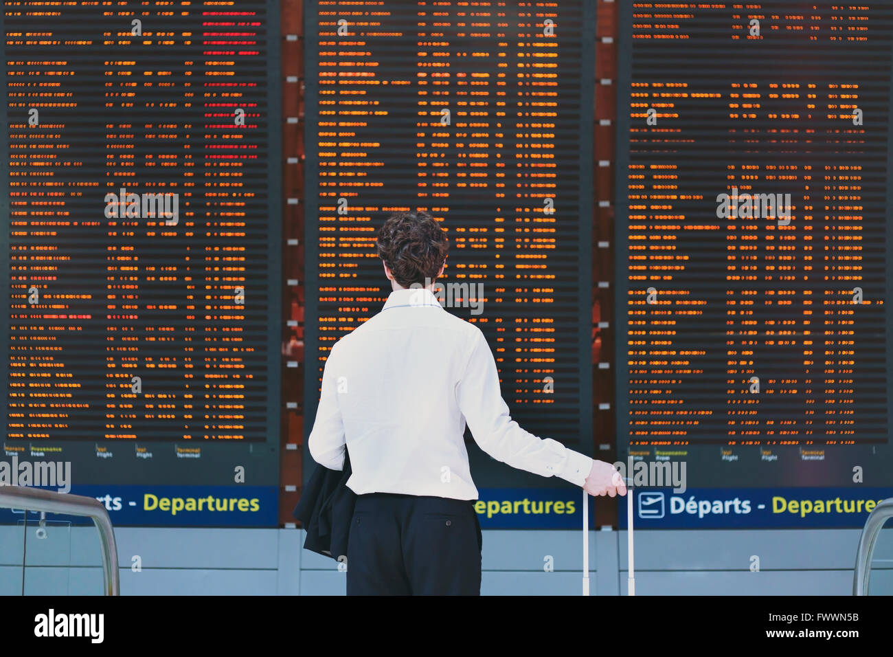 Les gens dans l'aéroport, les voyages d'affaires, à la recherche de passagers à bord de l'écran Calendrier Banque D'Images