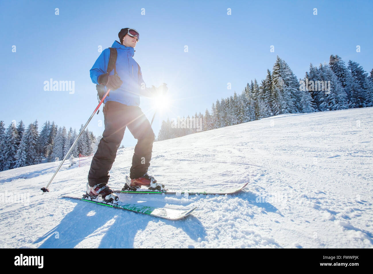En ski, sport d'hiver des Alpes, jeune skieur sur la pente en journée ensoleillée Banque D'Images
