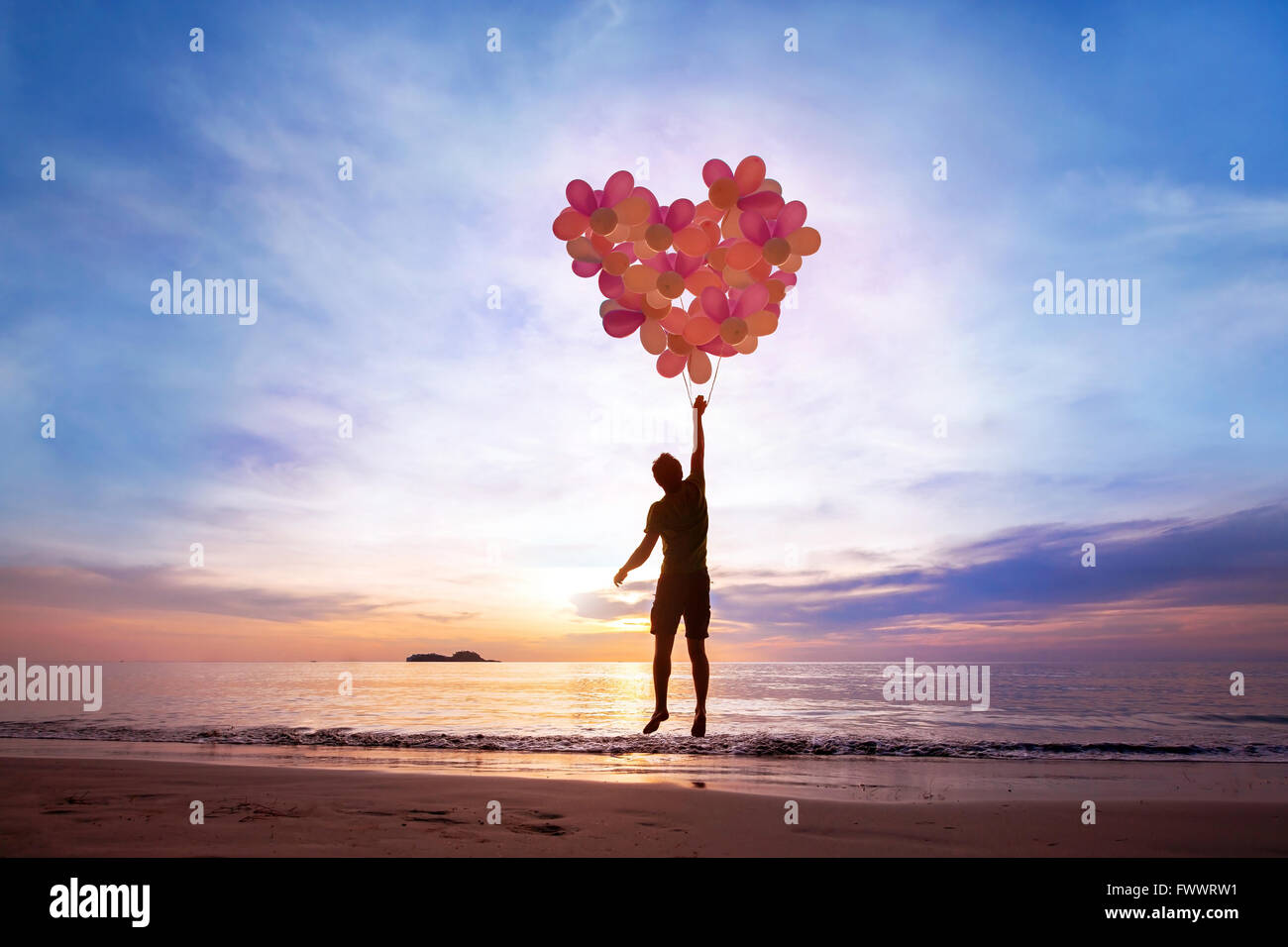 Concept L'amour, l'homme avec l'aide de ballons coeur battant, tomber en amour Banque D'Images