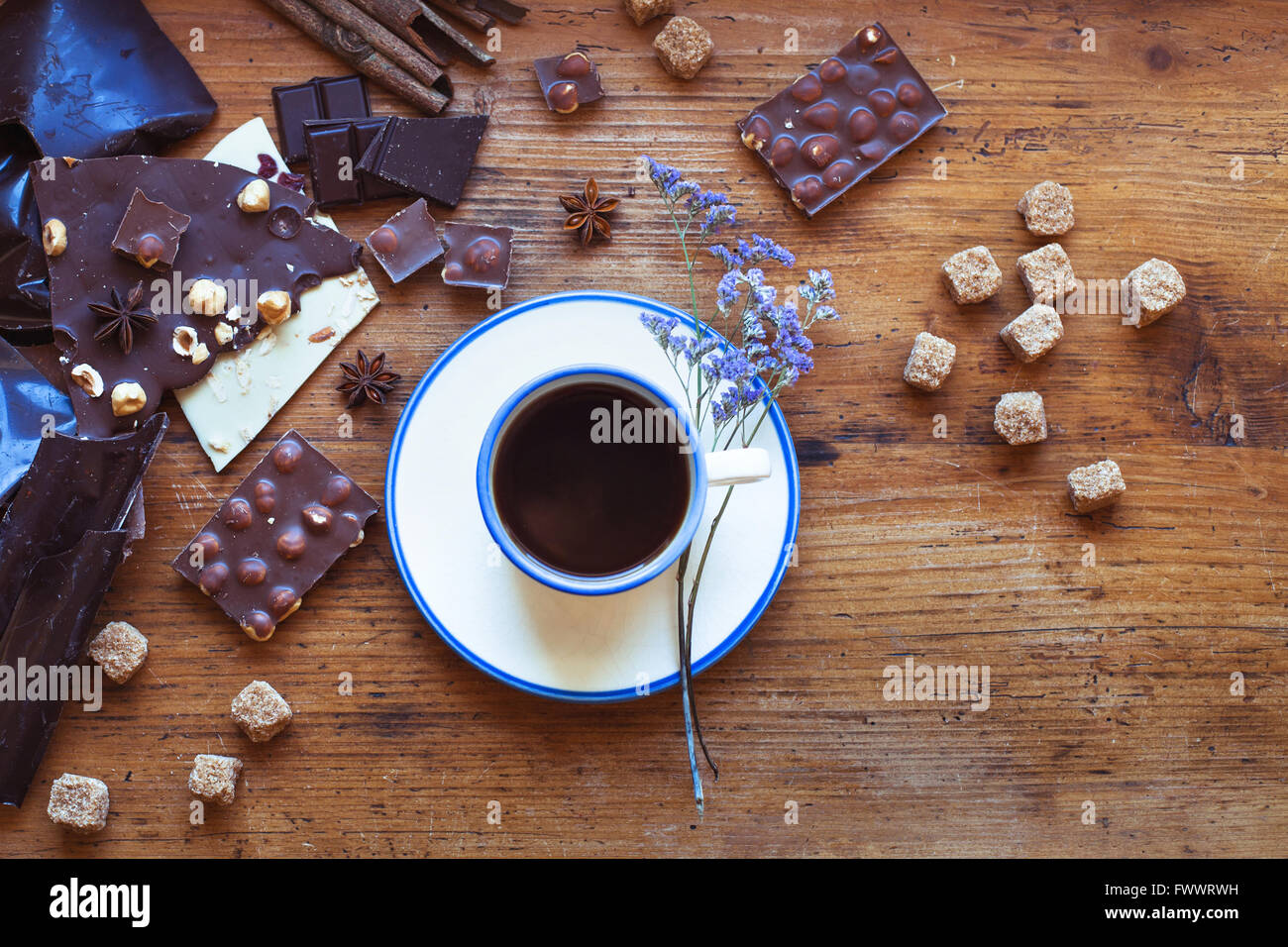 Tasse de café et différentes sortes de chocolat artisanal, vue du dessus sur fond de bois in cafe Banque D'Images