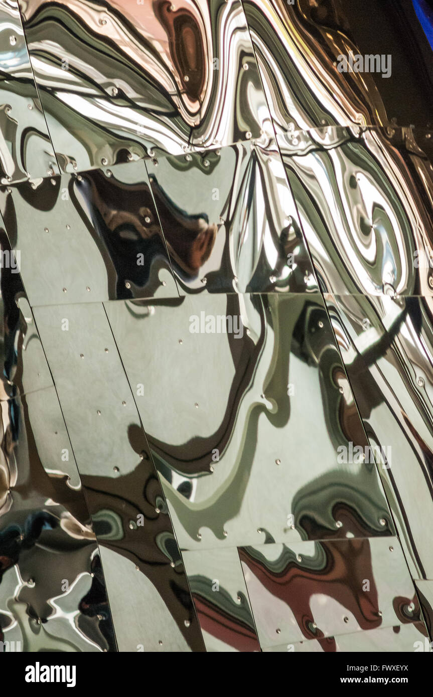 Reflets déformés dans un mur de feuilles de métal poli. Banque D'Images