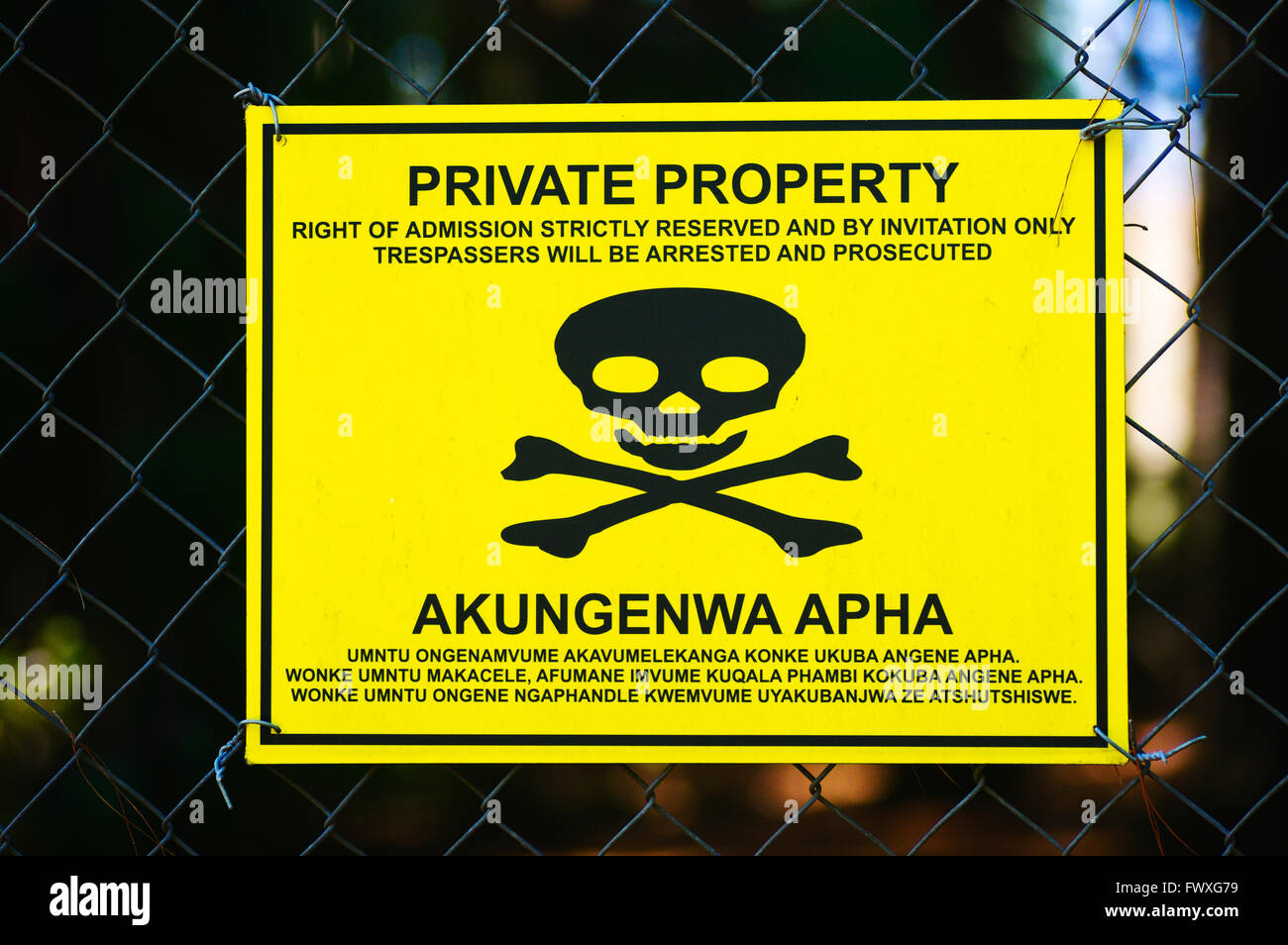 Panneau d'avertissement jaune Danger sur une clôture avec scull et d'os Banque D'Images