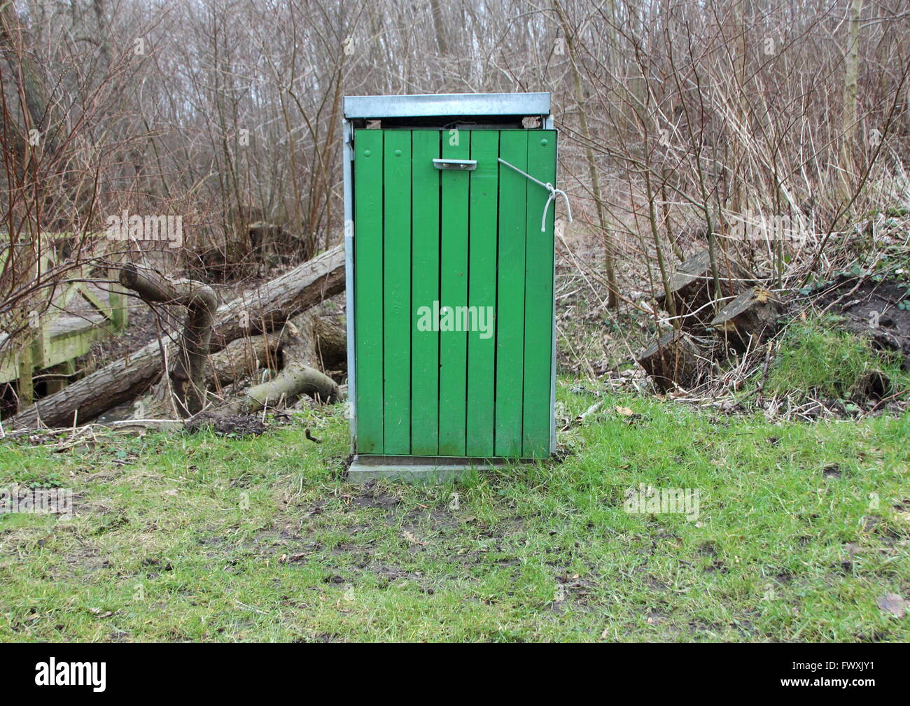 Poubelle en bois vert isolés en forêt avec couvercle de métal Banque D'Images