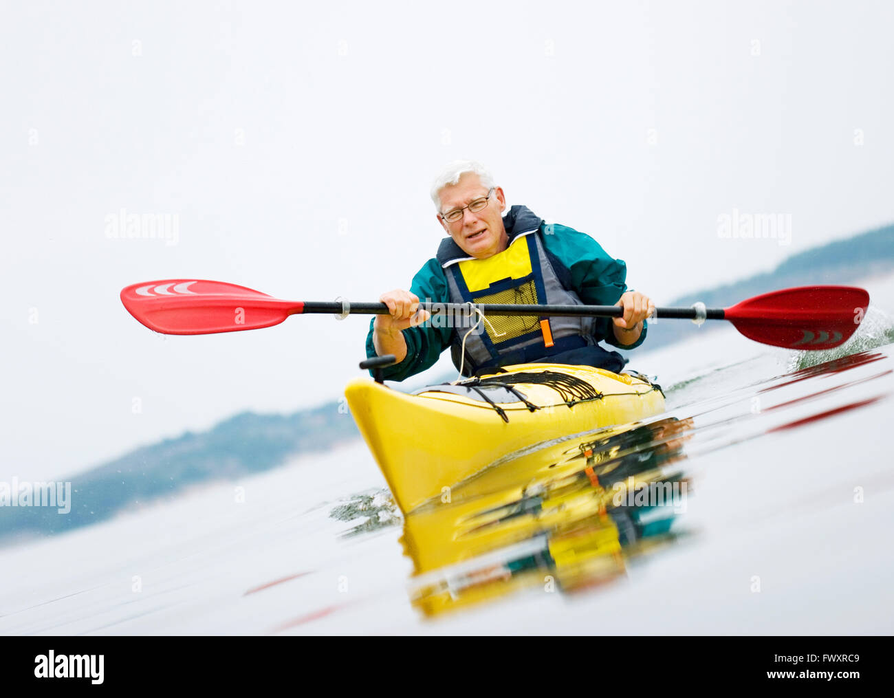 La Suède, Bohuslan, Tjorn, Senior man paddling kayak Banque D'Images