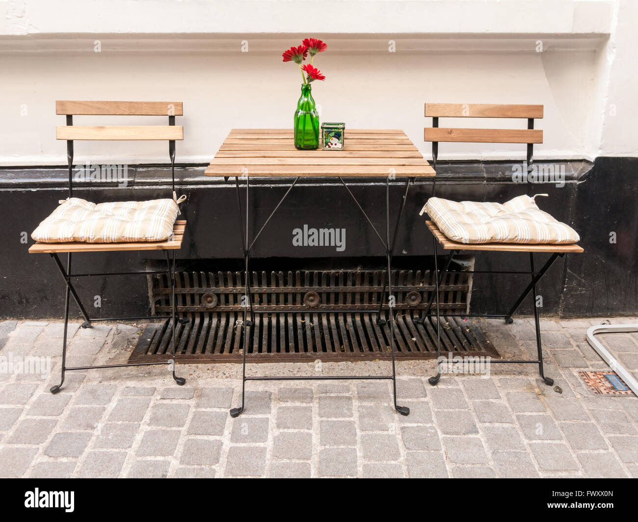 Tableau de fleurs et de deux chaises pliantes, terrasse en face de café dans le centre-ville d'Anvers, Flandre orientale, Belgique Banque D'Images