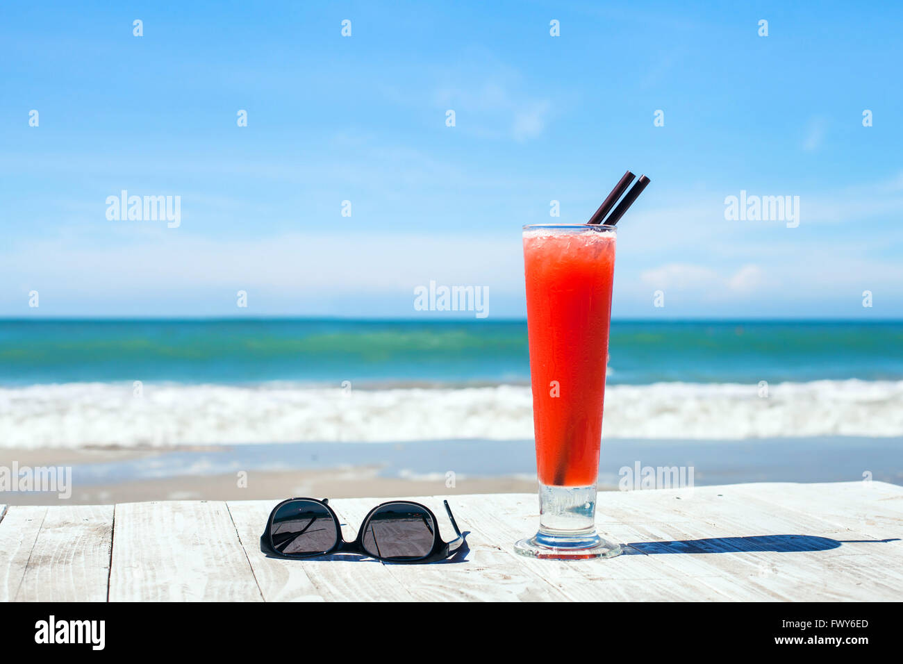 Vacances tropicales, l'arrière-plan avec cocktail et lunettes de soleil sur la plage Banque D'Images