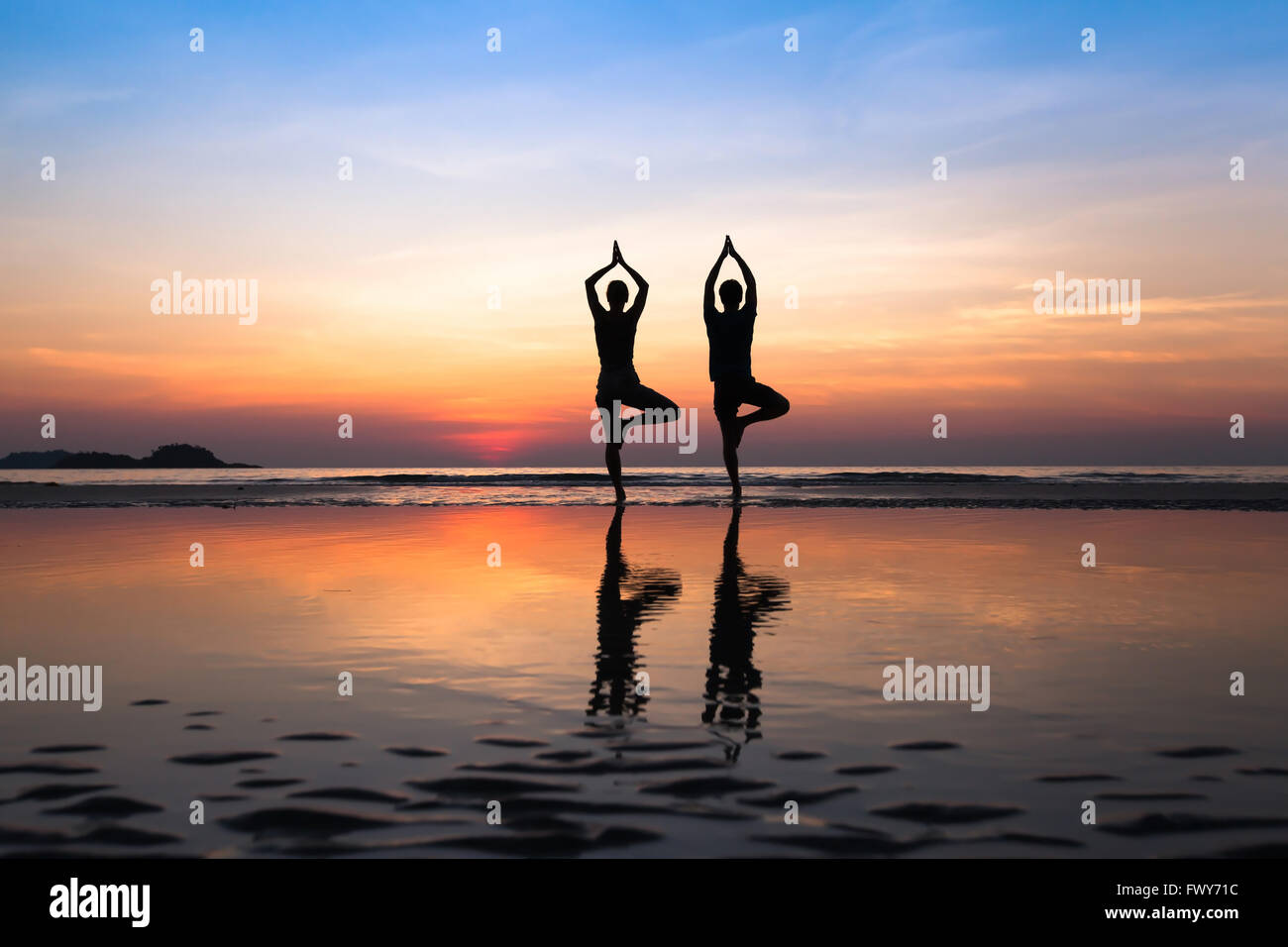 Yoga sur la plage, groupe de personnes qui pratiquent un mode de vie sain Banque D'Images