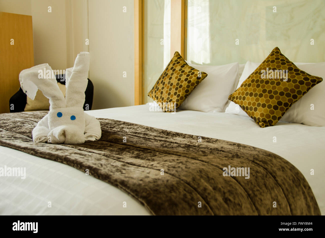 Blanc Marron chambre avec peluche blanc sur le couvre-lit marron. Banque D'Images