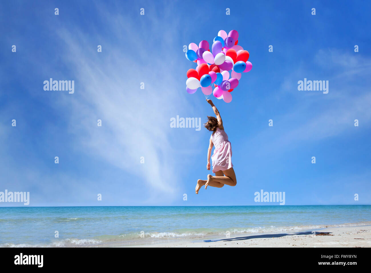 Dream concept, girl flying sur ballons multicolores dans le ciel bleu, de l'imagination et la créativité Banque D'Images