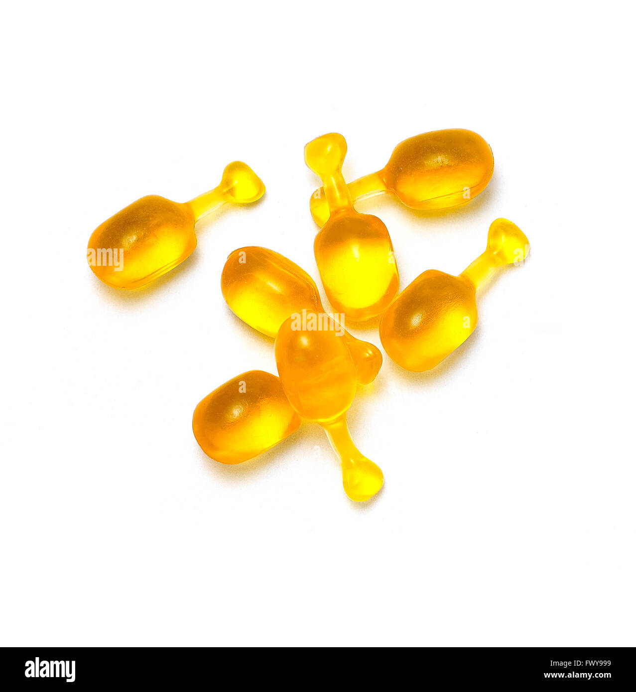 Capsules sérum jaune fond blanc Banque D'Images
