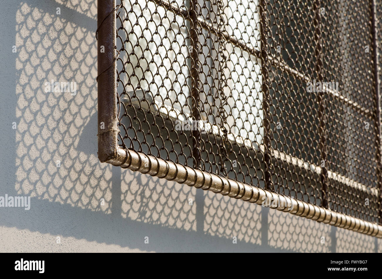 Fenêtre avec grille de sécurité à la lumière du soleil douce. Banque D'Images