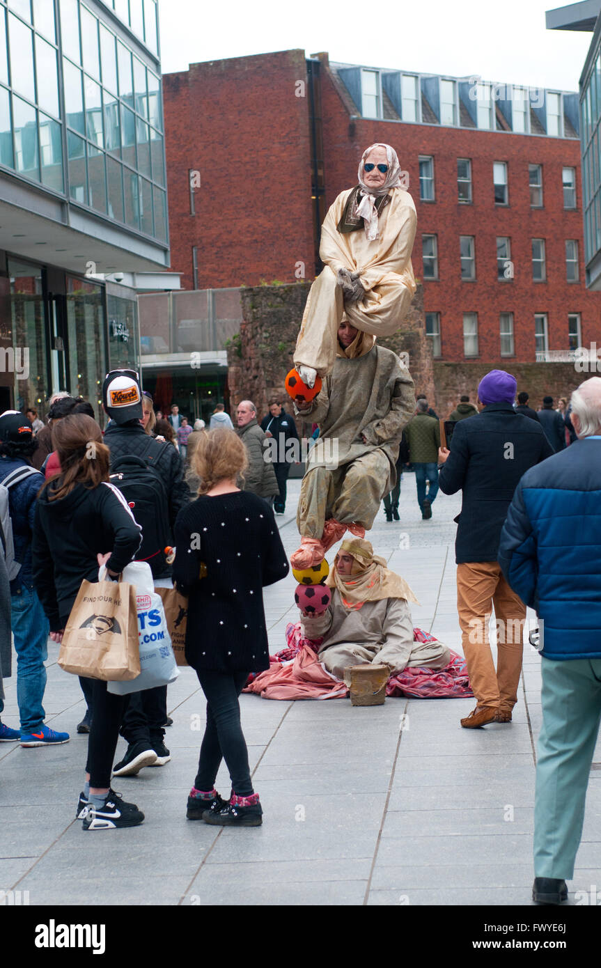 Les artistes de rue d'effectuer un acte d'équilibrage dans High Street, Exeter, UK Banque D'Images