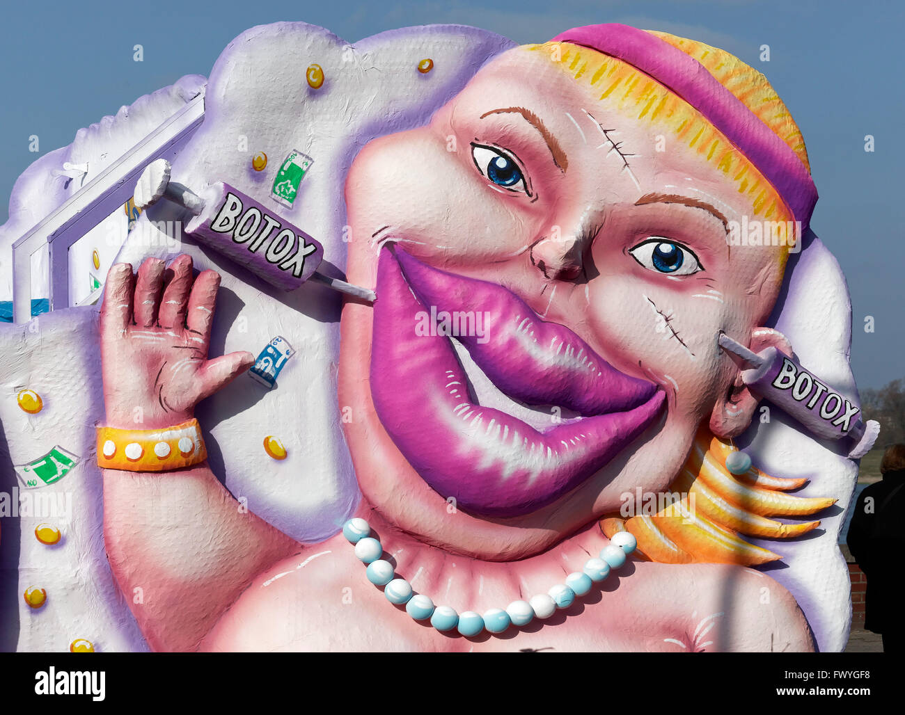 Femme avec des seringues de botox dans le visage, le papier mâché, le flottement avec caricature de Jacques Tilly, Rose Parade Lundi, Düsseldorf Banque D'Images
