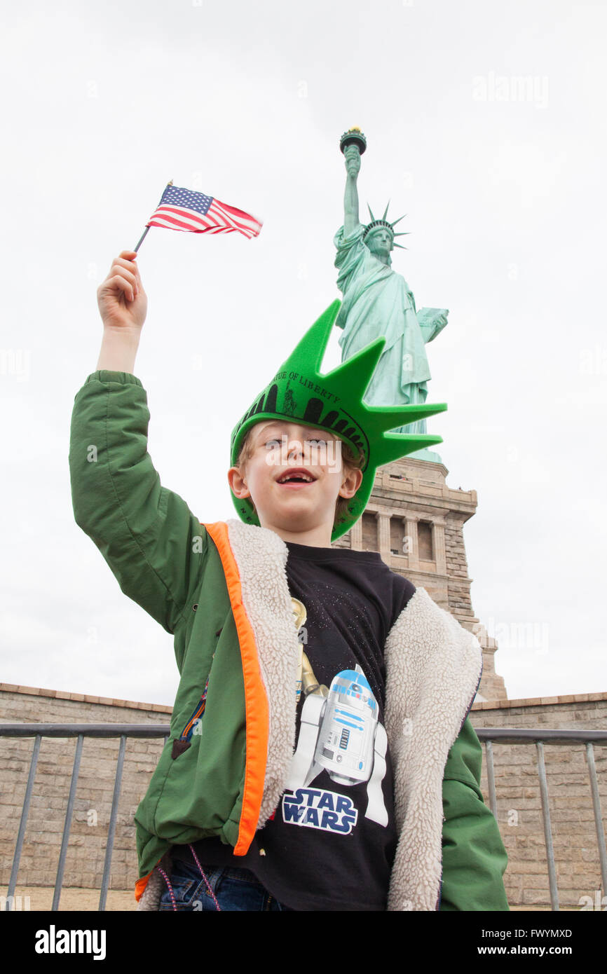 Six ans garçon debout en face de la Statue de la liberté, New York, Liberty Island, New York, États-Unis d'Amérique. Banque D'Images