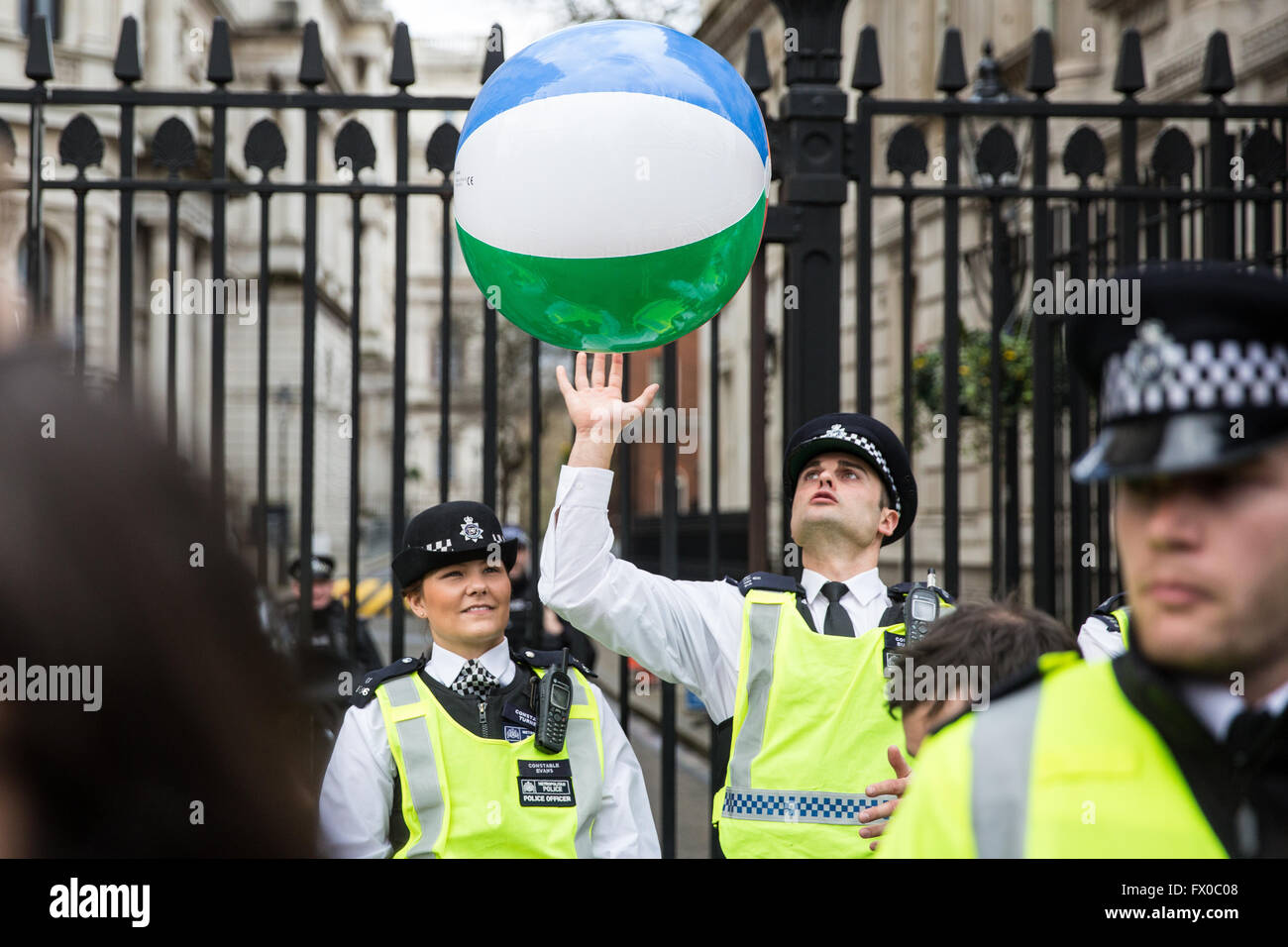 Londres, Royaume-Uni. Le 9 avril, 2016. Un policier lance un ballon de plage arrière de manifestants devant Downing Street à faire appel à David Cameron de "fermer les échappatoires fiscales ou démissionner" après les révélations contenues dans les documents 'Panama' sur son exploitation à la fin de son père sur les fonds offshore. Credit : Mark Kerrison/Alamy Live News Banque D'Images