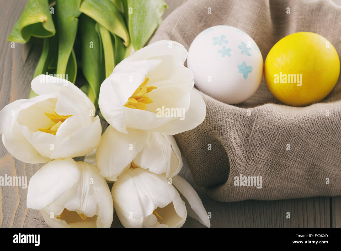 Couleur pastel des oeufs de pâques avec des tulipes sur la table Banque D'Images