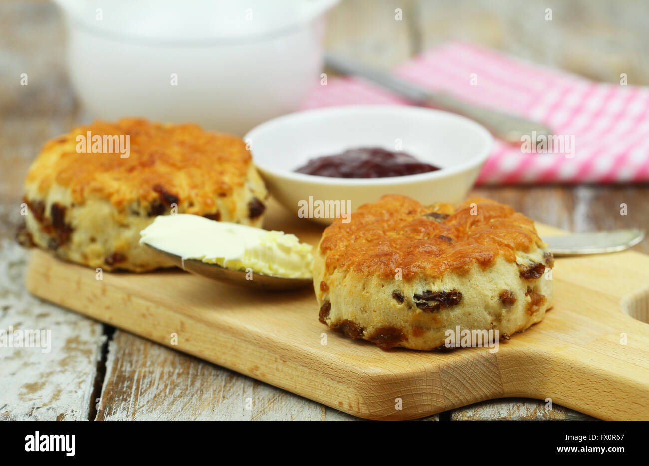 Des scones anglais avec des raisins sur planche de bois, crème caillée et jam Banque D'Images