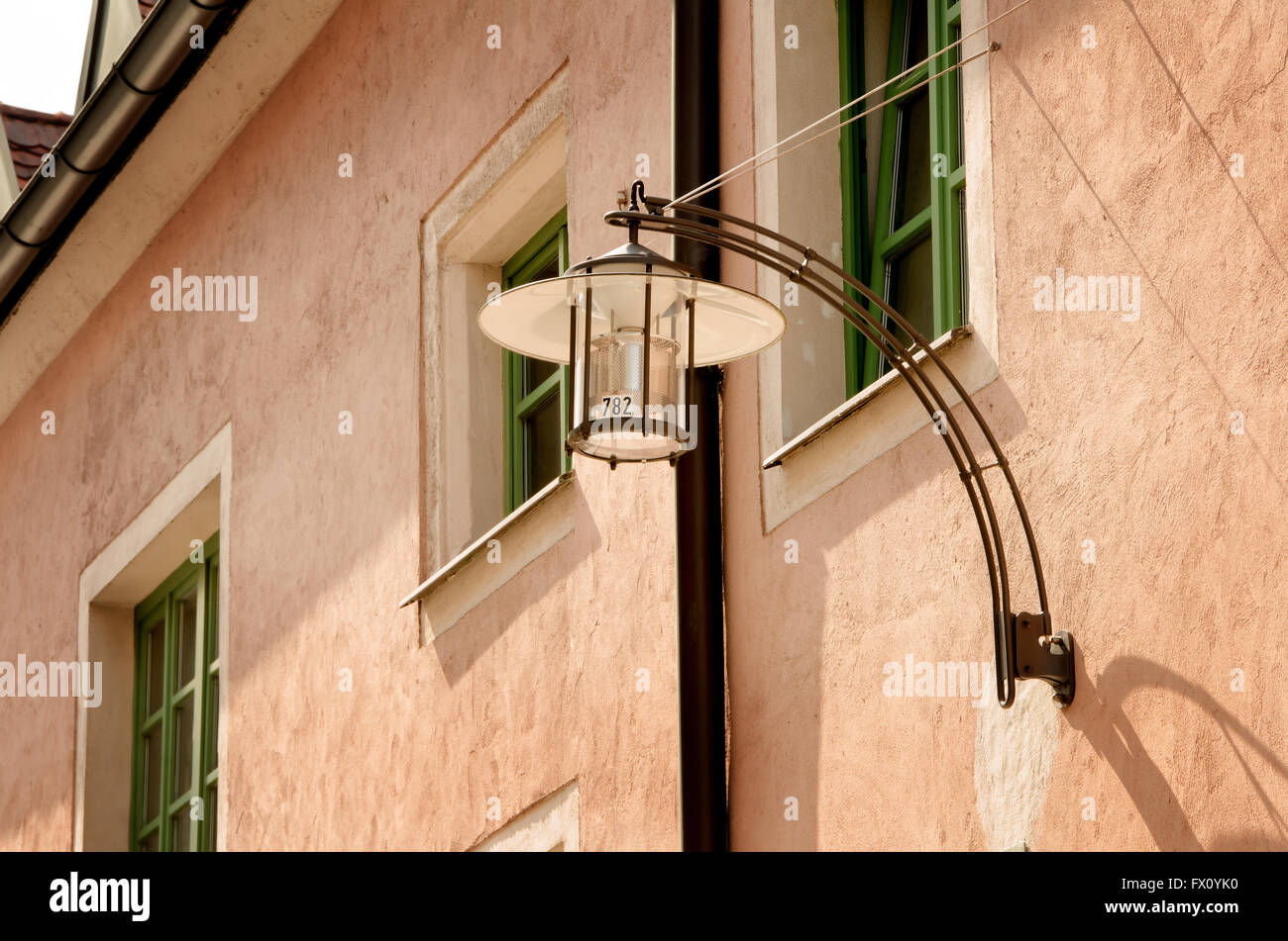 Lampe de rue sur la maison rose avec green windows. Banque D'Images