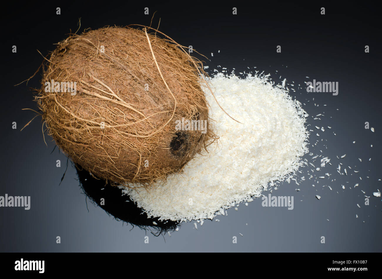 Tas de noix de coco desséchée et noix de coco entière isolé sur fond noir. Banque D'Images