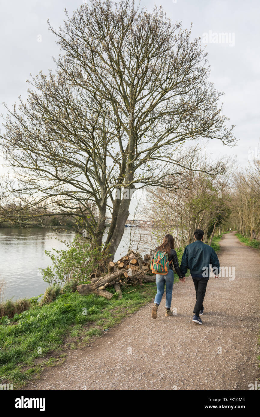 Un couple sur le chemin de halage le long de la Tamise dans le sud ouest de Londres, Royaume-Uni Banque D'Images