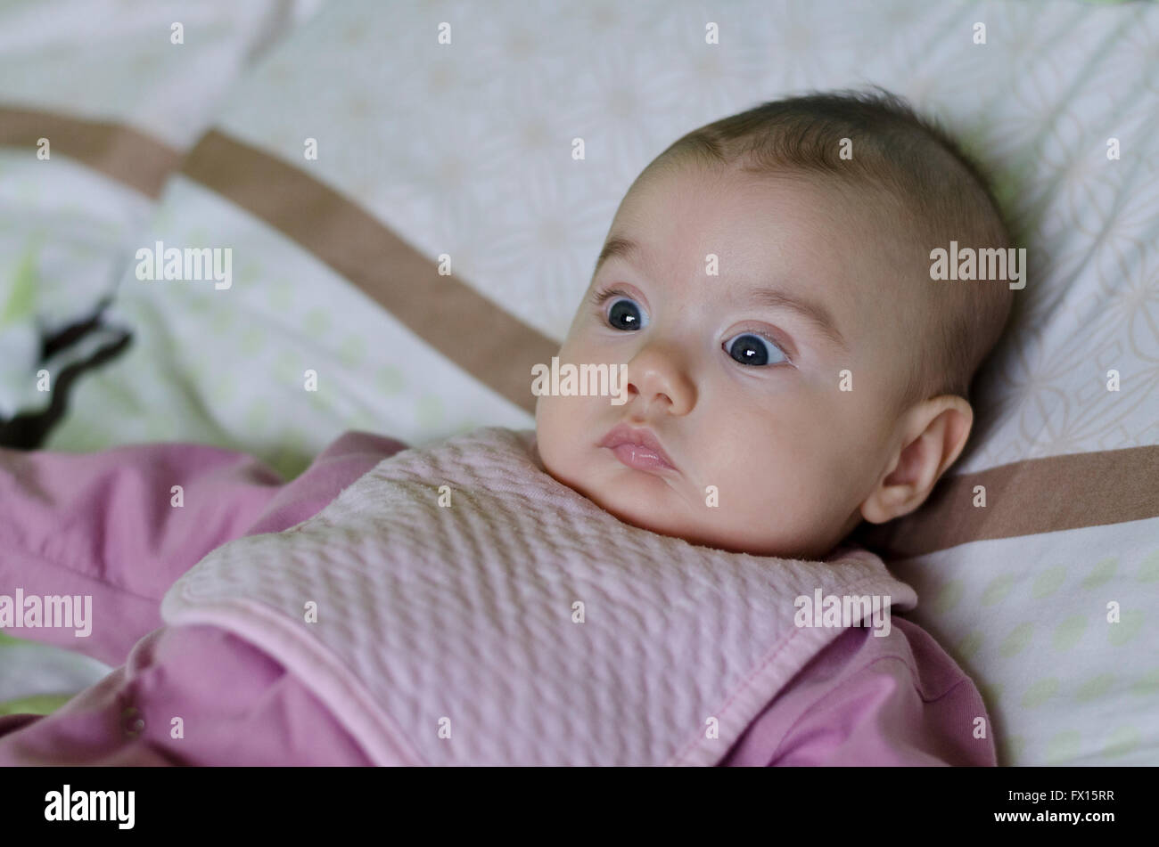 Une baby girl sitting on bed Banque D'Images