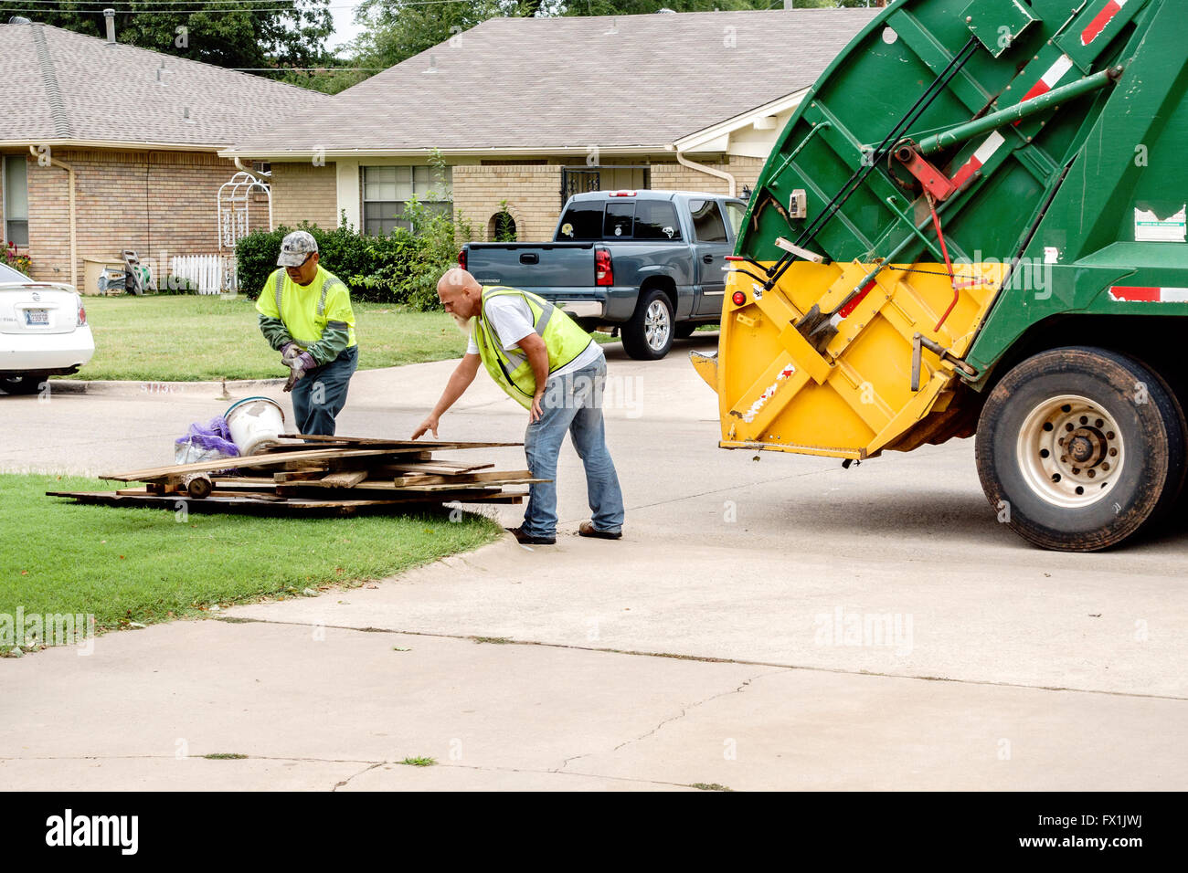 Deux hommes charger dans un camion à ordures détritus sur Grand Jour de détritus à Oklahoma City, Oklahoma, USA. Banque D'Images
