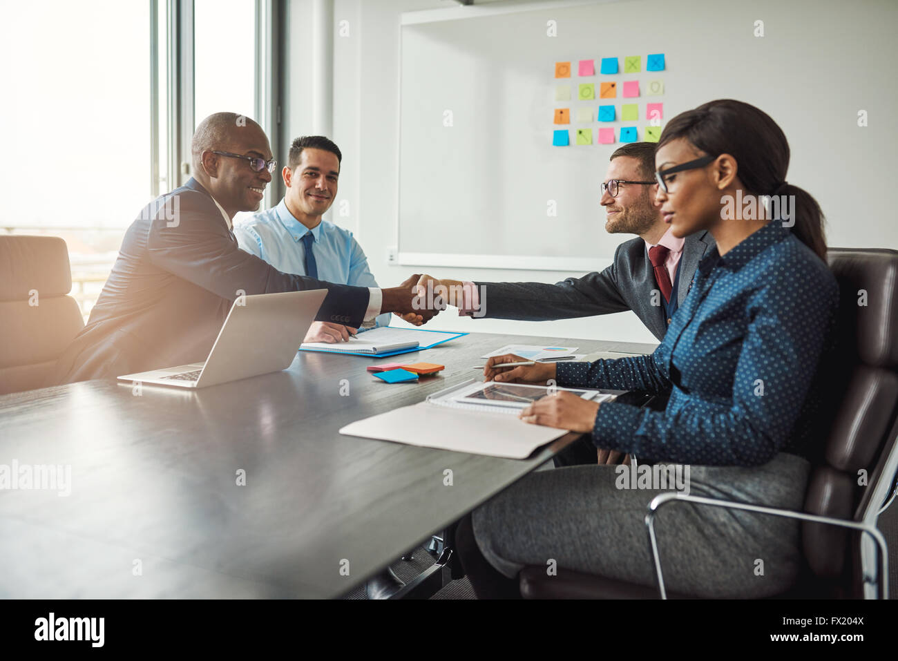 Deux jeunes équipes entreprises multiraciale, parvenir à un accord dans les négociations s'étendent à travers la table dans la salle de conférence à sh Banque D'Images