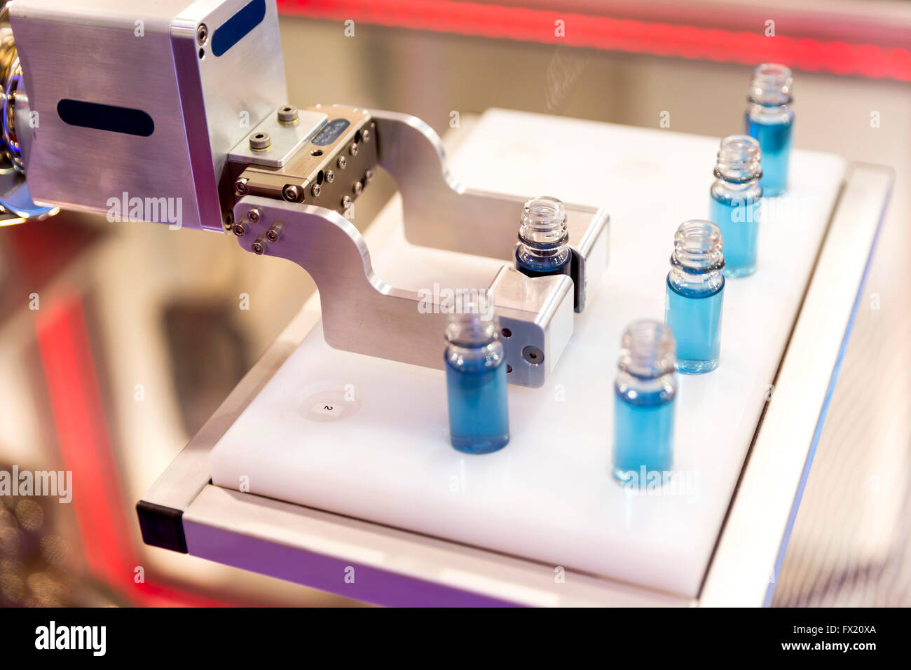 Bras mécanique robotique est la manipulation de substances chimiques avec plein tubes substance bleu dans un laboratoire médical au cours d'un essai. Banque D'Images
