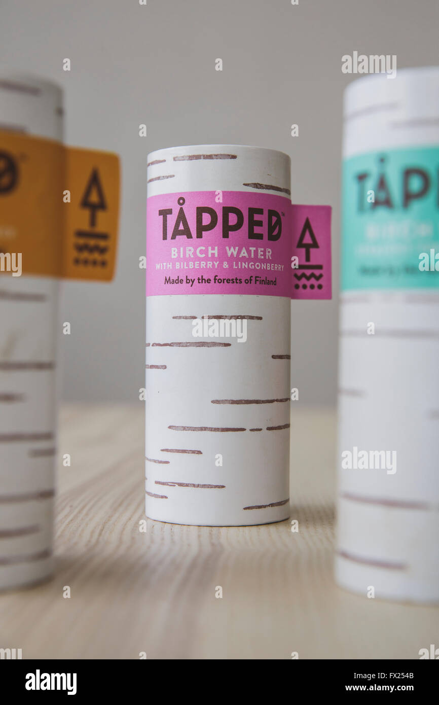 Cartons d'eau de bouleau taraudé sur une table de cuisine en bois d'une lumière naturelle. Banque D'Images