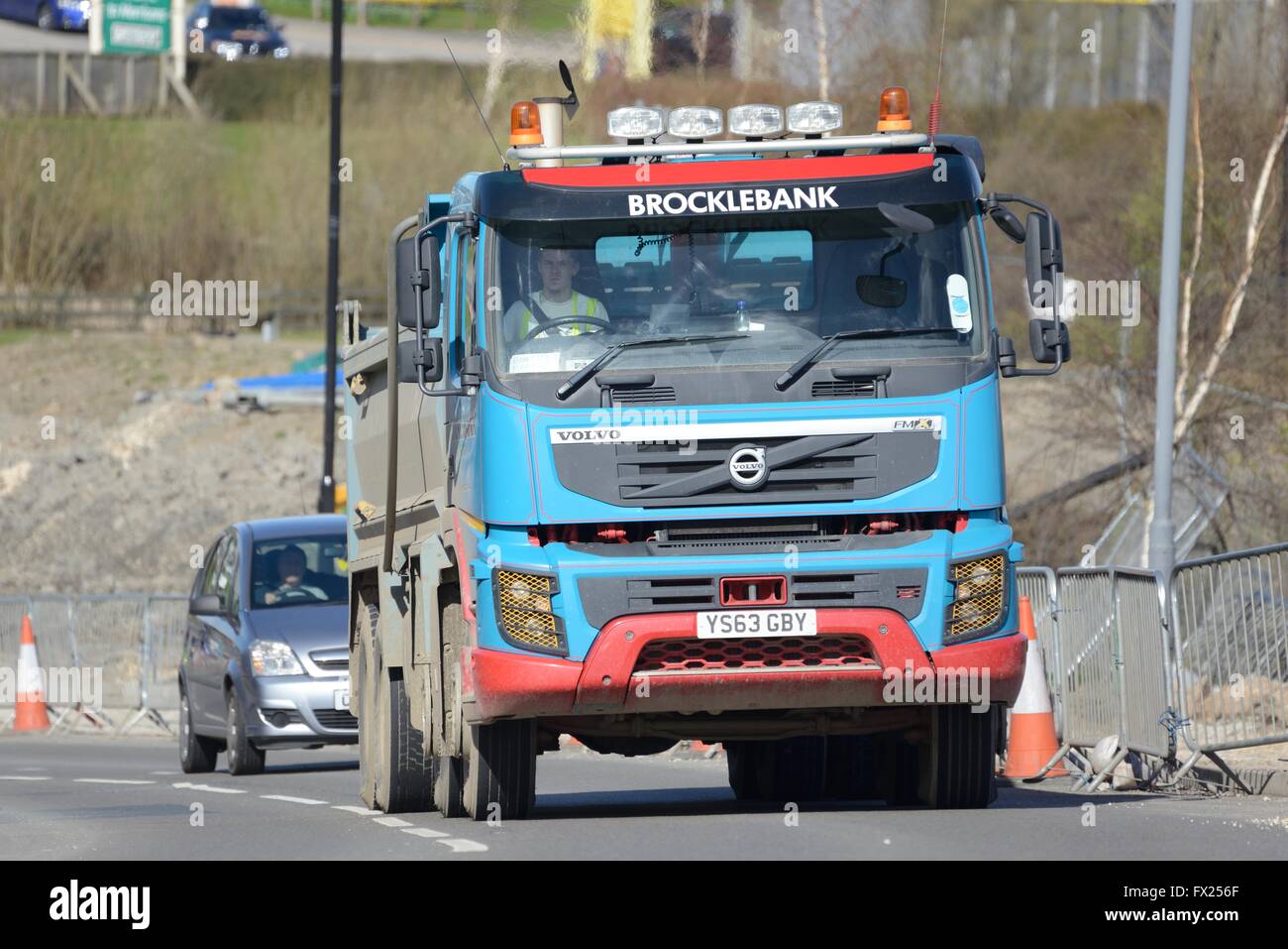 Un gros camion benne Volvo montée d'une colline à côté d'importants travaux routiers Banque D'Images