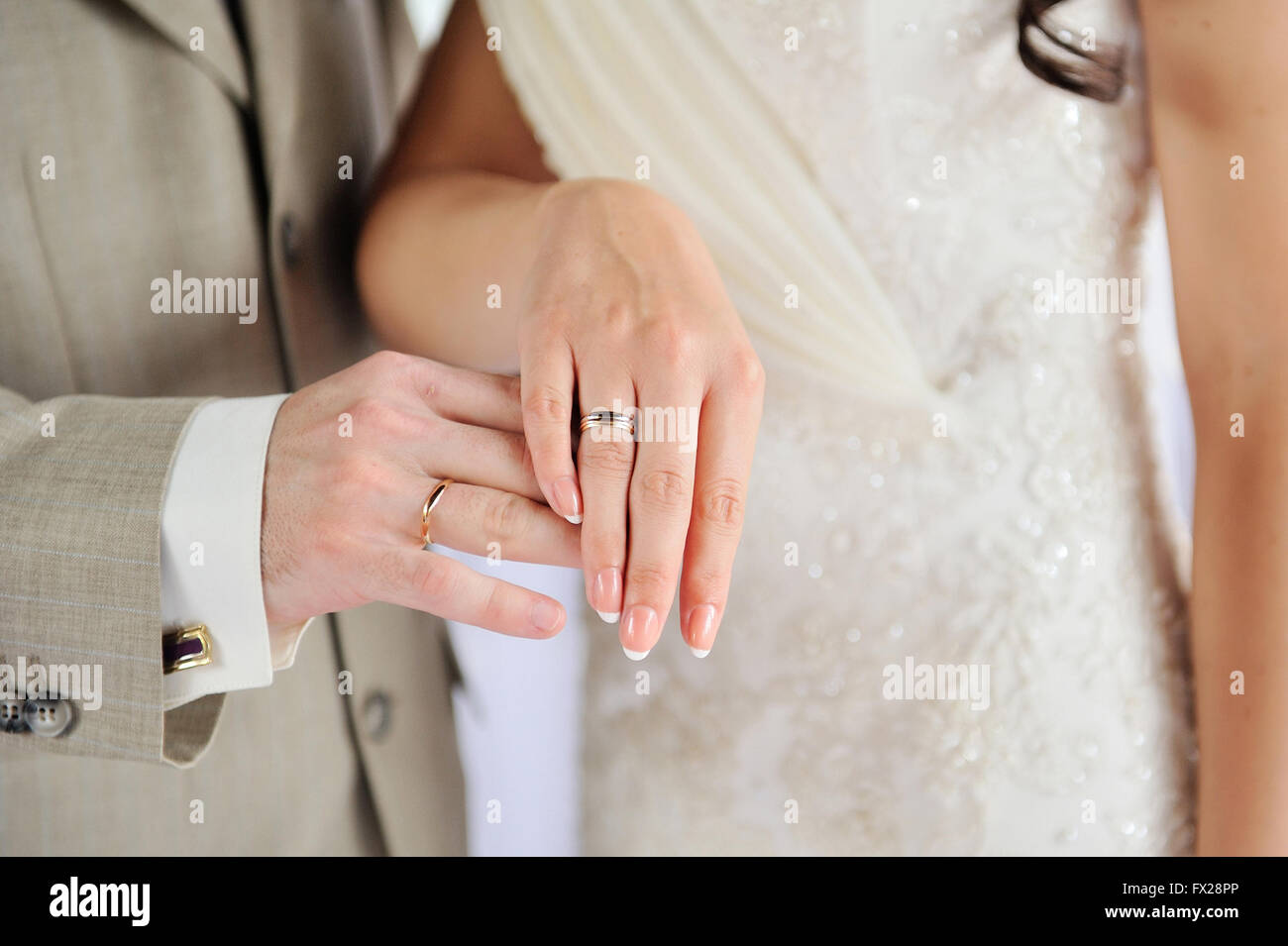 Mains de jeunes mariés avec des anneaux d'or sur le mariage Banque D'Images