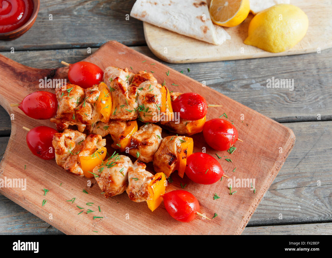 Shish kebab de Poulet avec tomate poivron brochette en bois Banque D'Images