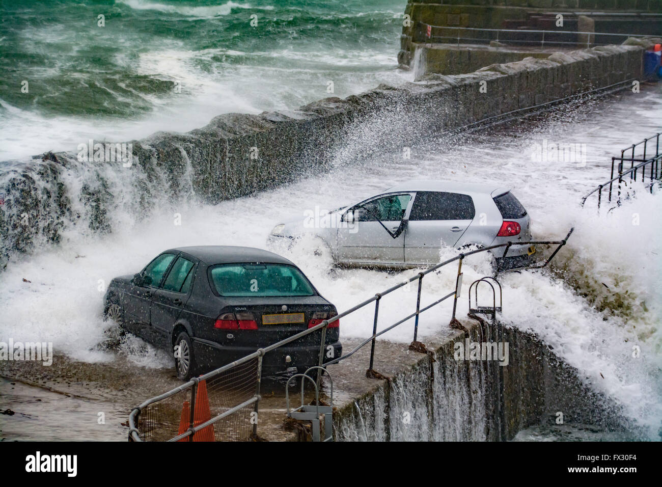 Mousehole, Cornwall, UK. 10 avril 2016. Météo britannique. Le moment la force de la mer presque pousse cette voiture dans le port de Mousehole, au cours de cette matinée d'énormes vagues. Crédit : Simon Maycock/Alamy Live News Banque D'Images