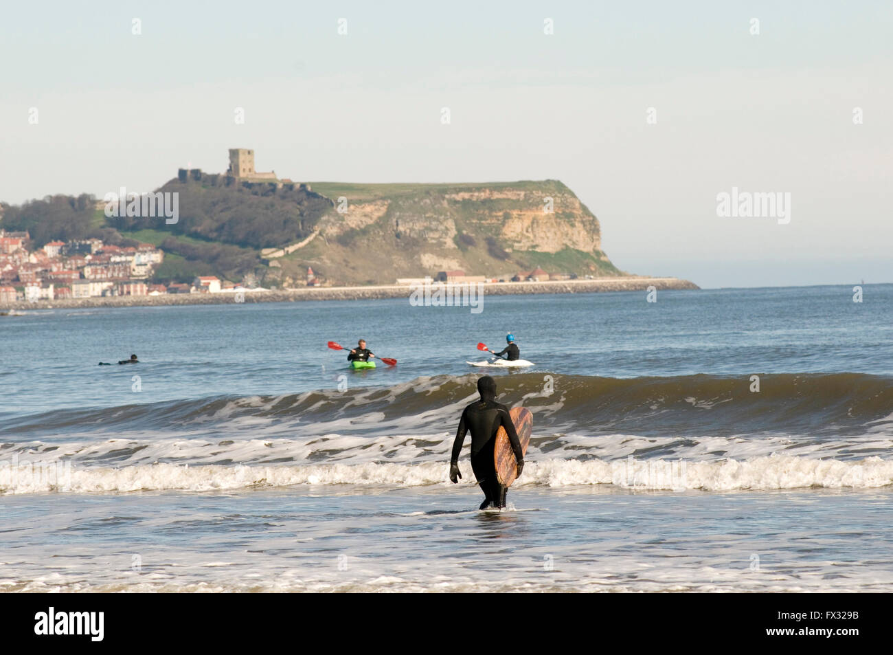 Cayton Bay, Scarborough, Royaume-Uni. 10 avril, 2016. Beau temps à Scarborough ; personnes surfant sur la mer du Nord ; à Cayton Bay ; le château de Scarborough en arrière-plan ; histoire de temps chaud et ensoleillé soleil anormalement anormalement histoires Crédit : picturesbyrob/Alamy Live News Banque D'Images