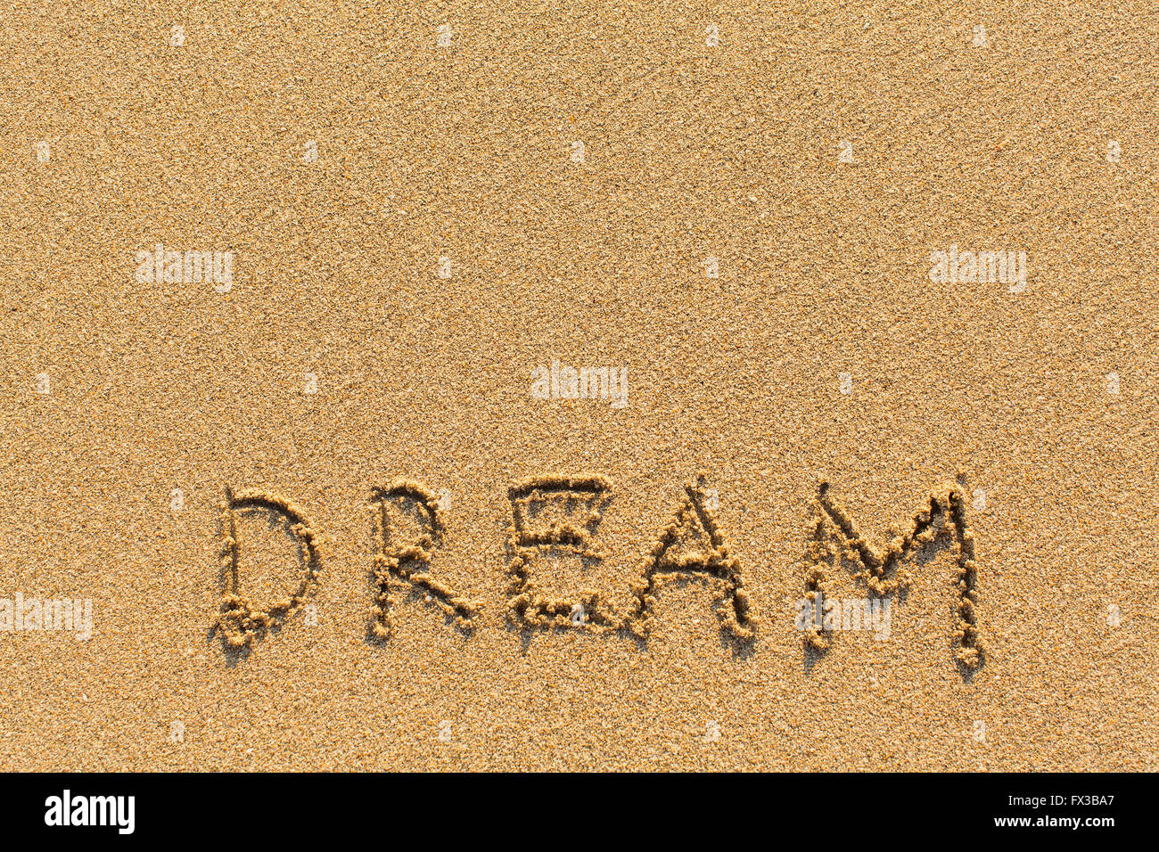 Dream - dessiné de la main sur la plage de sable. Banque D'Images