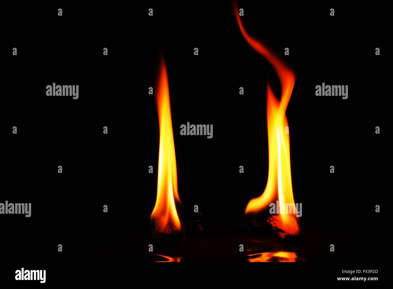 Deux flammes rouges et jaune isolé sur fond noir avec la réflexion sur le bas.vue horizontale. Banque D'Images Deux flammes rouges et jaune isolé sur fond noir avec la réflexion sur le bas.vue horizontale. Banque D'Images