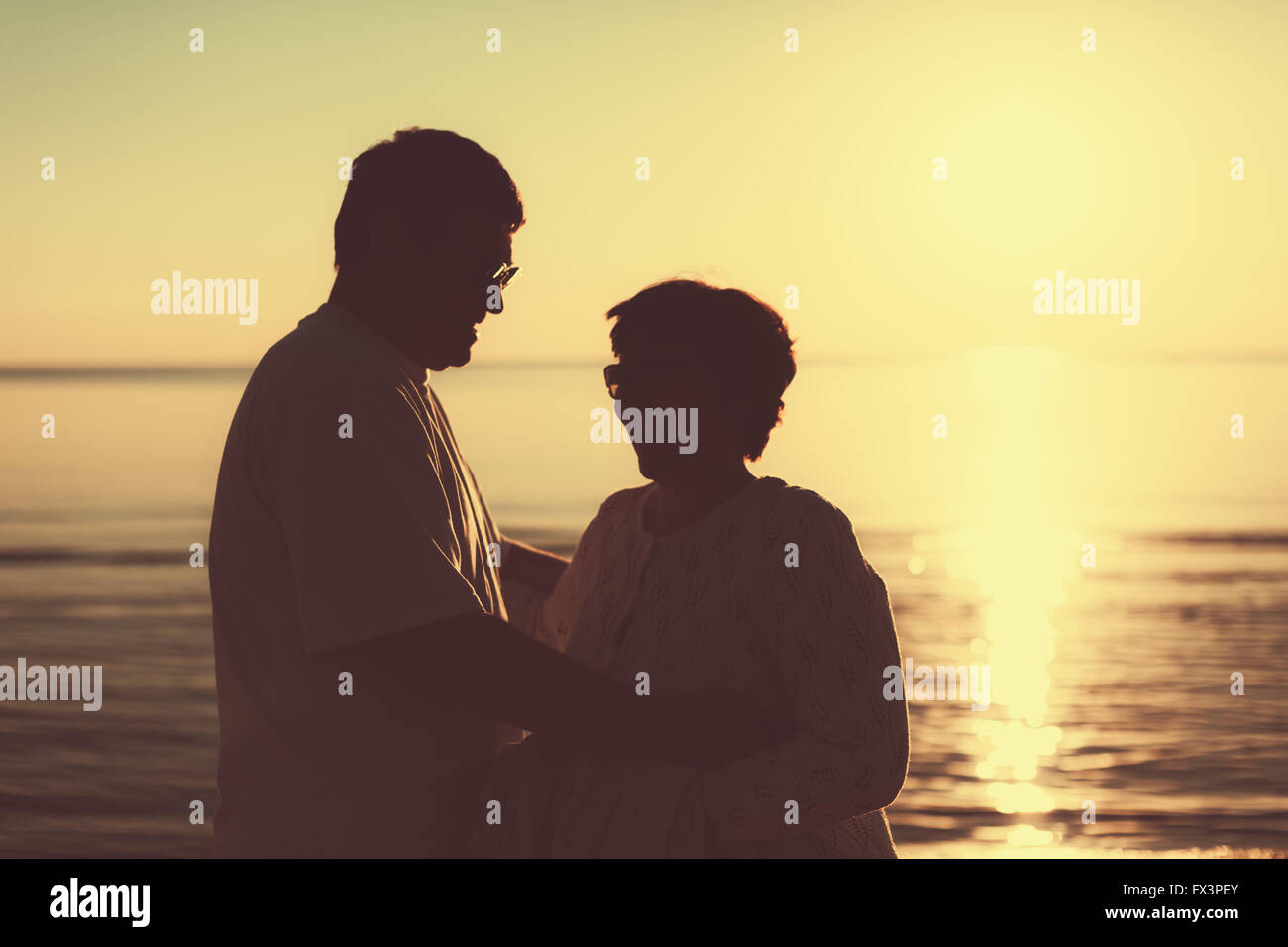 Couple adultes au coucher du soleil et de la mer. Banque D'Images