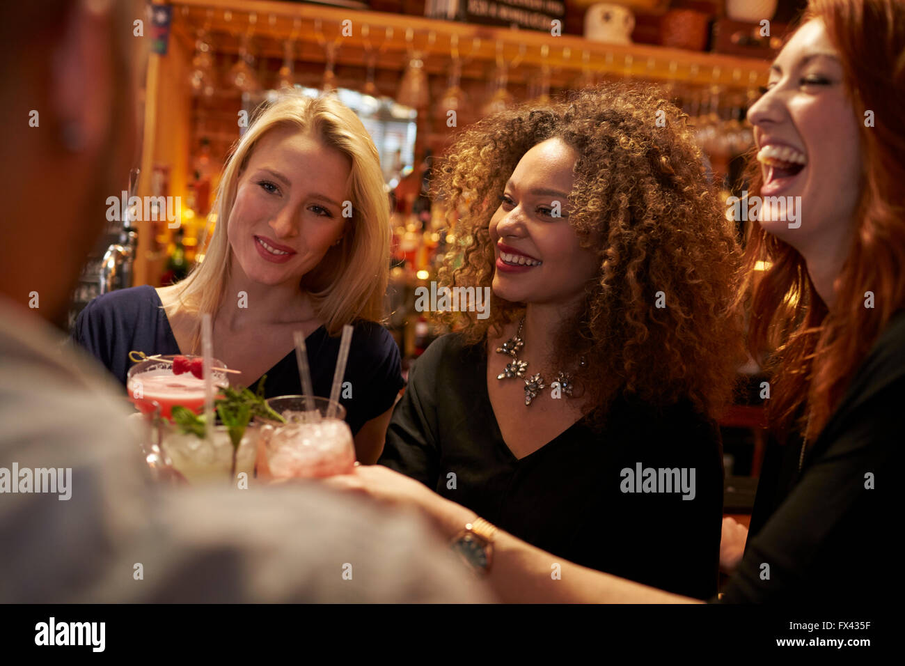 Réunion du Groupe des amis pour prendre un verre en soirée au bar à cocktails Banque D'Images