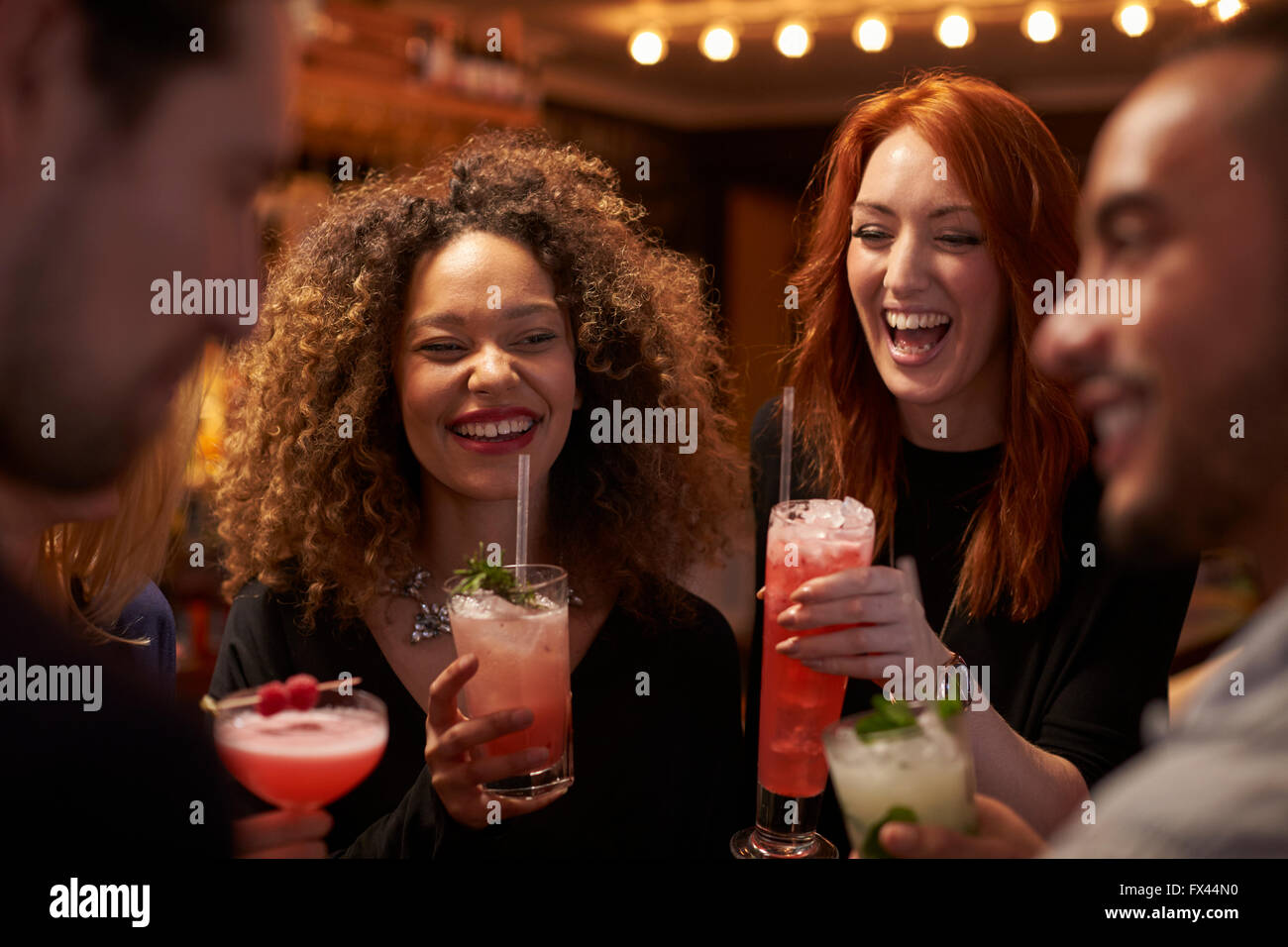 Réunion du Groupe des amis pour prendre un verre en soirée au bar à cocktails Banque D'Images