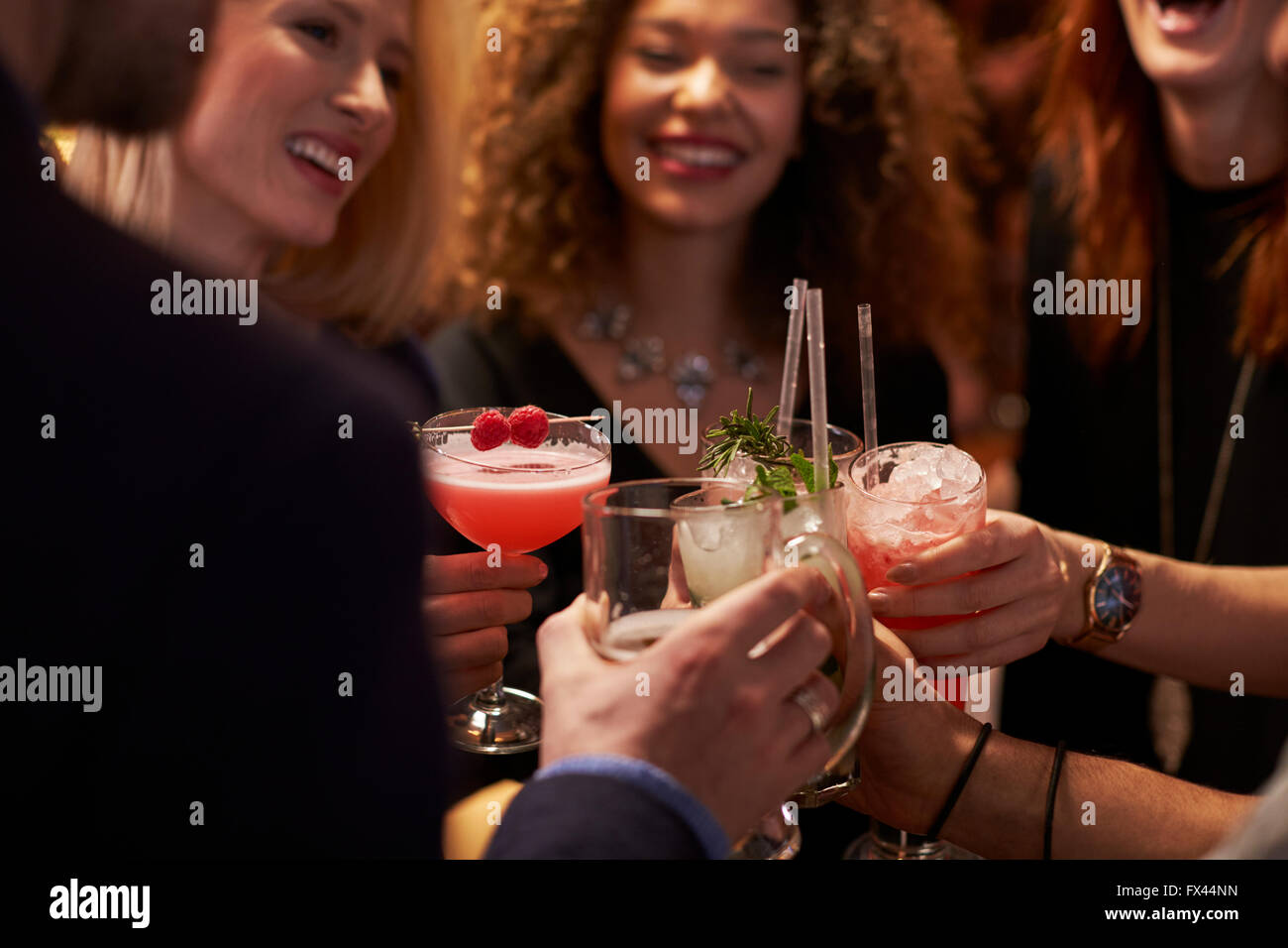 Groupe d'amis faire un toast en Bar à cocktails Banque D'Images