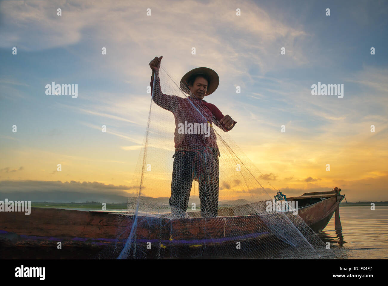 Au lac de pêche pêcheur en matin, en Thaïlande. Banque D'Images