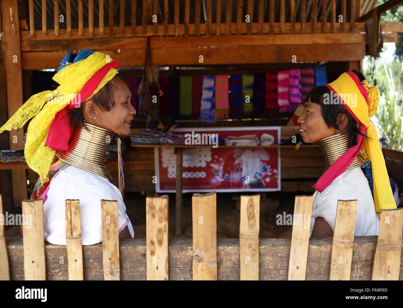 Demoso, Myanmar. Apr 11, 2016. Les femmes Padaung avec anneaux en laiton autour de leur cou chat à une boutique de cadeaux dans Demoso Panpet Village, Canton, l'État de Kayah, Myanmar, le 11 avril 2016. Les bagues en laiton sont d'abord appliqués lorsque l'filles Padaung sont environ huit ans et que la jeune fille grandit, plus les bobines sont ajoutés jusqu'à 24 ou 25 anneaux. © U Aung/Xinhua/Alamy Live News Banque D'Images