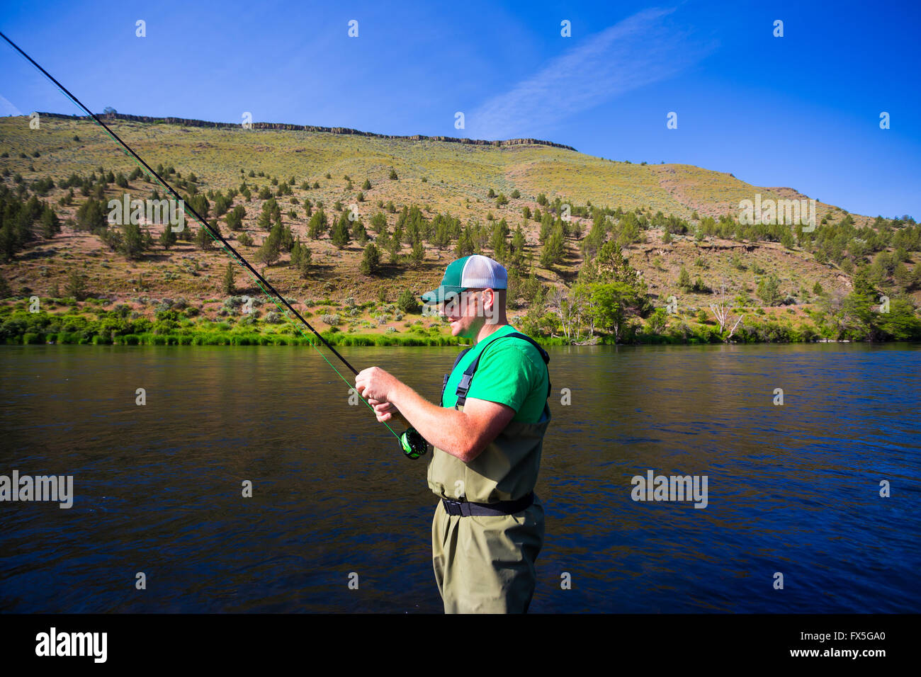 L'expérience de pêche pêche à la mouche la rivière Deschutes dans l'Oregon, le casting pour les poissons tout en se tenant dans l'eau. Banque D'Images