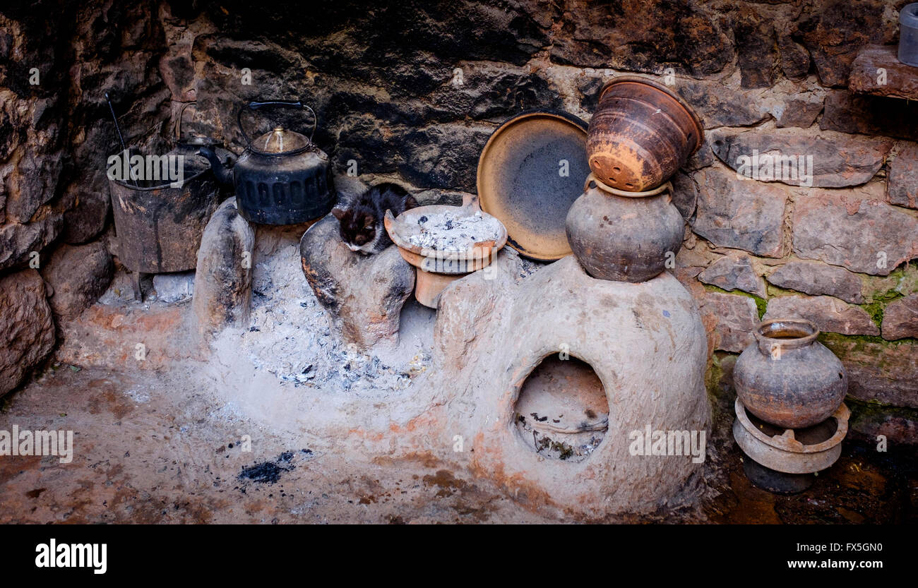 Un chat est assis près du feu et de la cuisson des pots dans une maison berbère dans la vallée de l'Ourika au Maroc, l'Afrique du Nord Banque D'Images