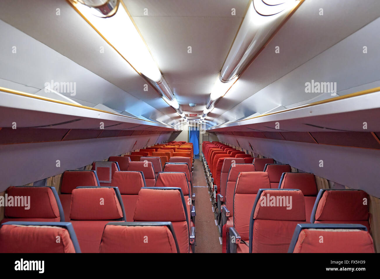 Cabine de l'avion avec des sièges rouges usés d'un vieil avion Banque D'Images