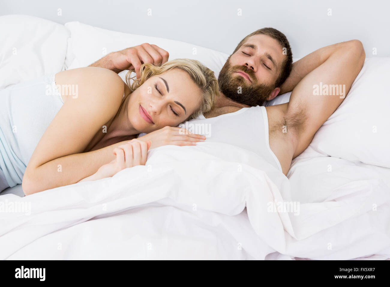 Couple sleeping on bed Banque D'Images