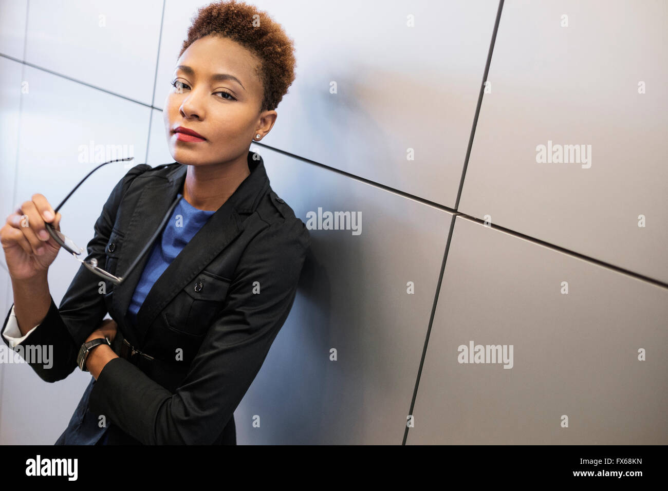 Mixed Race businesswoman holding eyeglasses Banque D'Images