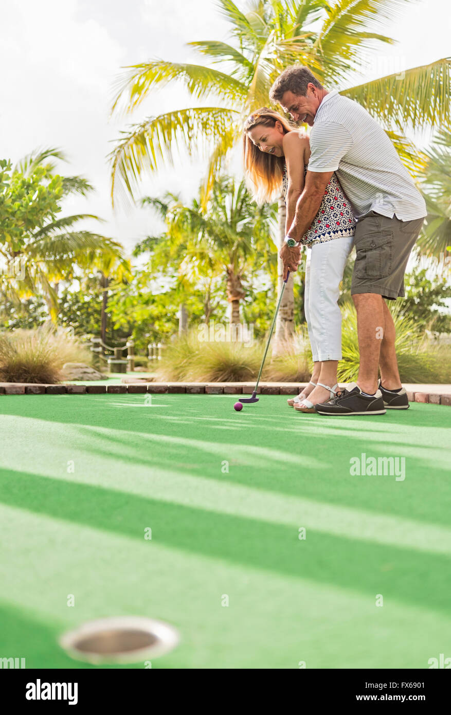 Caucasian couple playing miniature golf Banque D'Images