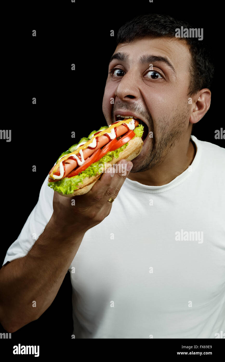 Armenian man eating hotdog Banque D'Images