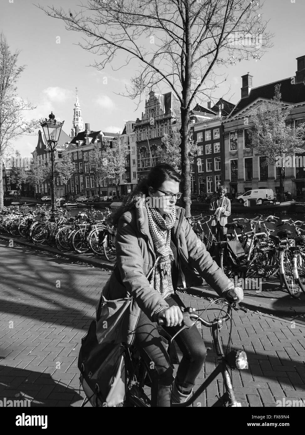 Woman riding a bicycle par canal à Amsterdam Banque D'Images